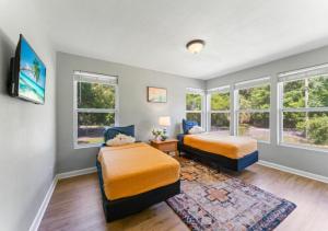 two beds in a room with windows and a rug at Delightful 4 Bedroom Luxury House In Jacksonville in Jacksonville