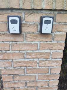 two electrical boxes on a brick wall at Mobil-home Côté Mur in Holque +3 photos