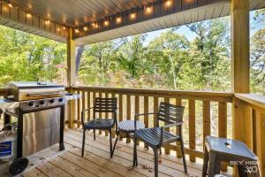 a screened in porch with two chairs and a stove at NEW! Boho Bungalow in Bella Vista
