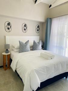 Un dormitorio con una gran cama blanca y una ventana en Cozy Garden Facing Guest Suite -(Back up power) en Midrand