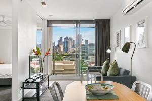 a living room with a table and a view of a city at East Melb 2bed parking pet friendly in Melbourne