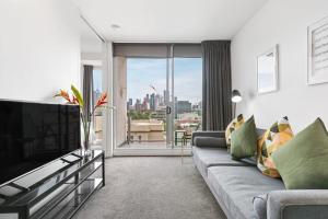 a living room with a couch and a tv at East Melb 2bed parking pet friendly in Melbourne