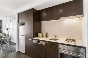 una cocina con fregadero y refrigerador en East Melb 2bed parking pet friendly, en Melbourne