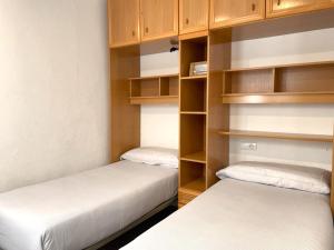 2 letti in una camera con scaffali in legno di MARQUINA - Apartamento con fantásticas vistas al mar a Cadaqués