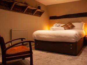 a bedroom with a bed with a chair and towels at The Wiremill in Felbridge