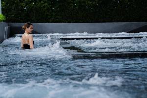 a woman standing in a pool of water at The Salil Hotel Riverside Bangkok in Bangkok