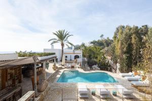 a pool in a yard with chairs and a house at Buccara Villa Mistral in Villajoyosa