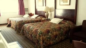 una stanza d'albergo con due letti e una sedia di Executive Inn & Suites a Lakeview