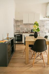 una cucina con tavolo in legno e sedie nere di Alla Fiera apartment a Bergamo