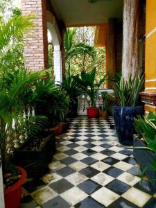 un patio con suelo a cuadros en blanco y negro y plantas en Brightness Villa , Private Home Stay en Phumĭ Poŭthĭ Mâ Srei