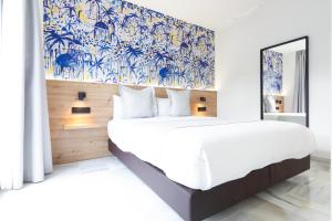 a bedroom with a large bed with blue and white wallpaper at Hotel La Milagrosa in Alicante