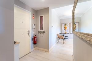 a hallway with white walls and a fire extinguisher at Serene Ocean 1 BDR Apartment With Patio by LovelyStay in Portimão