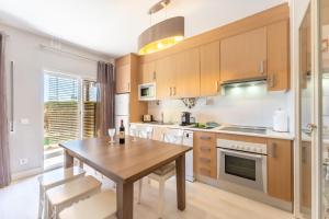 a kitchen with a wooden table and a dining room at Serene Ocean 1 BDR Apartment With Patio by LovelyStay in Portimão