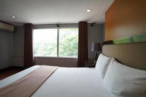 a bedroom with a bed with a large window at Arzo Hotel Manila in Manila