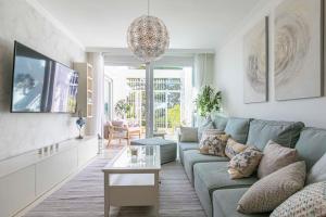 uma sala de estar com um sofá azul e uma mesa em MAGNIFIQUE appartement 2 Ch, 2 Sdb, au cœur des plus beaux GOLFS em Benahavís