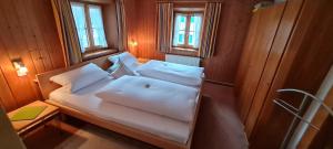 a small room with a bed with white pillows at Gästehaus Unruh in Oberammergau