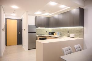 a kitchen with a counter and a refrigerator at New Contemporary 1BR Apt in Jumeirah Garden City in Dubai