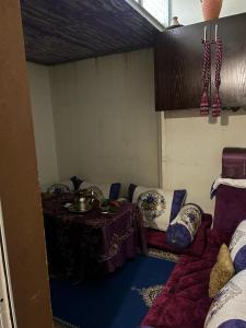 Zimmer mit einem Tisch und einem Sofa mit Kissen in der Unterkunft Très belle appartement agadir in Agadir