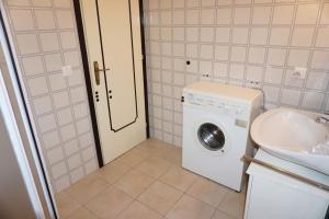 ein Badezimmer mit Waschmaschine und Waschbecken in der Unterkunft A few steps from the beach in Porto Santa Margherita