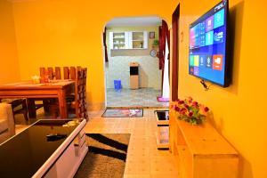 sala de estar con TV y comedor en THE PINGS BNB, en Narok