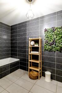 un baño con una pared de azulejos negros y un toallero. en Reflet du Veyrier 4 étoiles - Proche lac & Vieille Ville, Garage privé, Secteur recherché, en Annecy