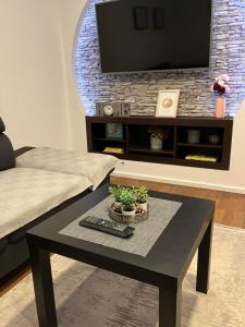 a living room with a coffee table and a flat screen tv at Apartman Gaby in Virovitica