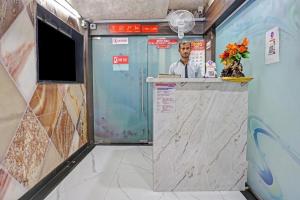 a room with a counter with a man behind it at Hotel Viraj in Pune