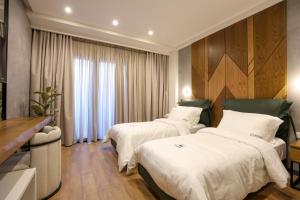 ein Hotelzimmer mit 2 Betten und einem Fenster in der Unterkunft Garden Boutique Hotel in Tirana