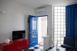 een woonkamer met een blauwe deur en een tv bij Apart Garzas Reales in Vera