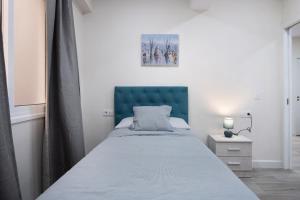 een bed met een blauw hoofdeinde in een slaapkamer bij Apartamento en Casa telmo in Santa Cruz de la Palma