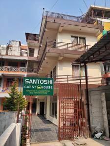 a building with a sign for a guest house at santoshi guest house in Pokhara
