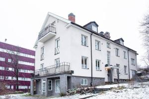 a white building with snow on the ground at Modern 1 Bed Gem Stylish City Apartment in Stockholm