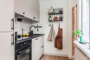 una pequeña cocina con fregadero y nevera. en Modern 1 Bed Gem Stylish City Apartment en Estocolmo