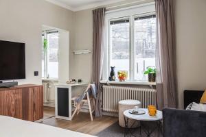 Habitación con cama, TV y ventana. en Modern 1 Bed Gem Stylish City Apartment en Estocolmo