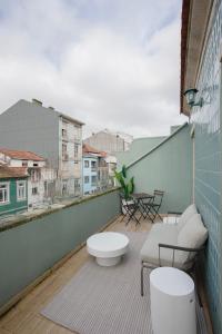 uma varanda com um banco e uma mesa num edifício em Liiiving in Porto - Downtown Quiet House no Porto