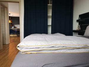 uma cama com lençóis brancos num quarto em Apartma Elton em Gornja Radgona