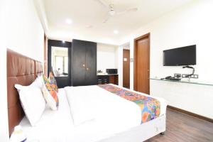 a bedroom with a white bed and a flat screen tv at ESTA STAY WAKAD in Méribel Village
