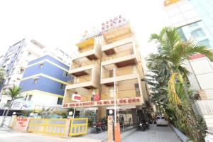 a tall building with palm trees in front of it at ESTA STAY WAKAD in Méribel Village