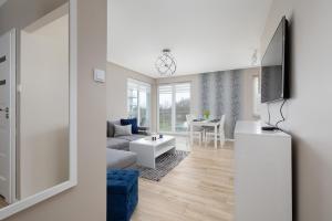 a living room with a couch and a table at Seaside Porta Mare Apartment with Balcony Kołobrzeg by Renters in Kołobrzeg