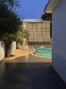 uma piscina com uma palmeira ao lado de uma casa em The Farmerian Resort em Belparāo