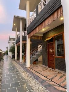 a building with a staircase on the side of it at The Farmerian Resort in Belparāo