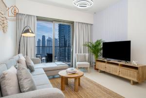 a living room with a flat screen tv and a large window at Family Apartment with Burj Views at Top Floor 175BC-3 in Dubai