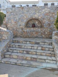 un muro di pietra con scale di fronte a un edificio di Ελένη a Megalochori (Isola di Agistri)
