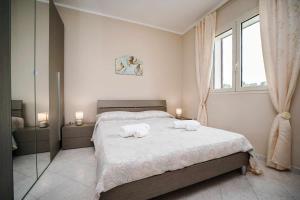 una camera da letto con un letto con due asciugamani sopra di Casa di Alice By Vivimy a Gallipoli