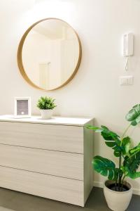 a dressing table with a mirror and a plant at San Felice Residence in Bologna