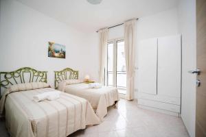 una camera da letto con due letti e una finestra di Casa di Alice By Vivimy a Gallipoli