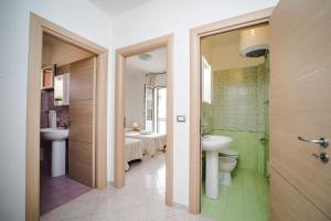 un bagno con lavandino, wc e doccia di Casa di Alice By Vivimy a Gallipoli