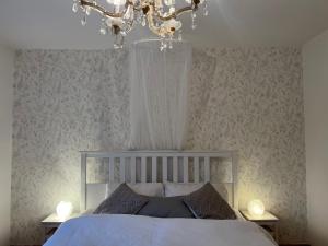 1 dormitorio con cama y lámpara de araña en Haus mit Garten, en Eugendorf