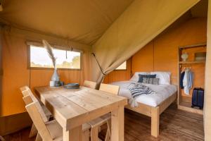 una camera con letto e tavolo in tenda di Il Castagno Toscana Glamping a Campiglia Marittima