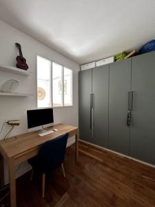 Cette chambre dispose d'un bureau et d'un ordinateur. dans l'établissement Appartement 2 chambres à 10 min de Paris, tout confort, à Clichy